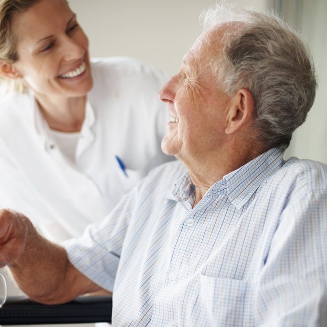 Alter Patient mit Pflegerin im Dialog