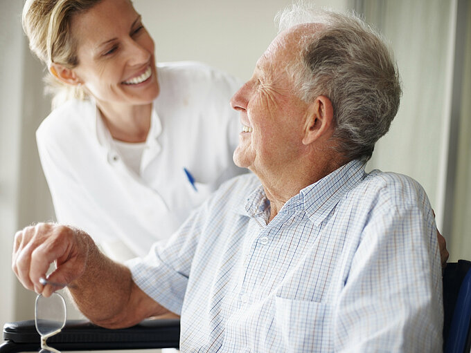 Alter Patient mit Pflegerin im Dialog