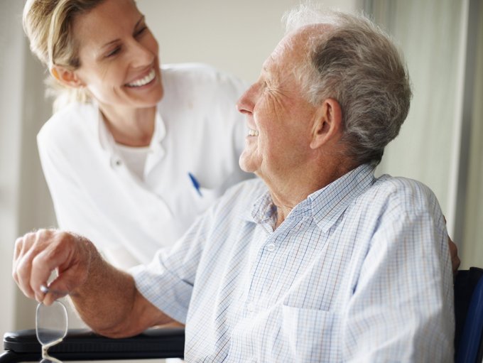 Alter Patient mit Pflegerin im Dialog